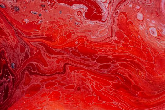 Vibrant red abstract art with swirling liquid paint patterns, perfect for creative design backgrounds.
