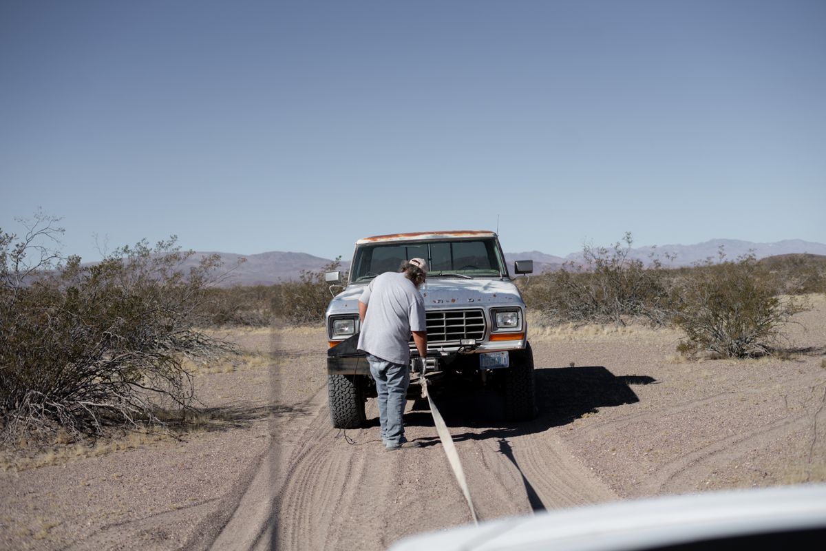 Stranded pickup truck in desert terrain needing off-road vehicle recovery assistance