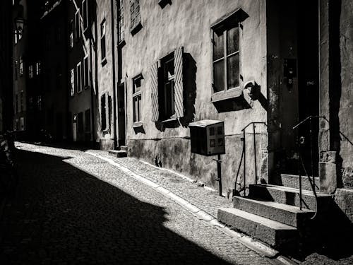 Free Old Building Near a Narrow Street in Grayscale Photography Stock Photo