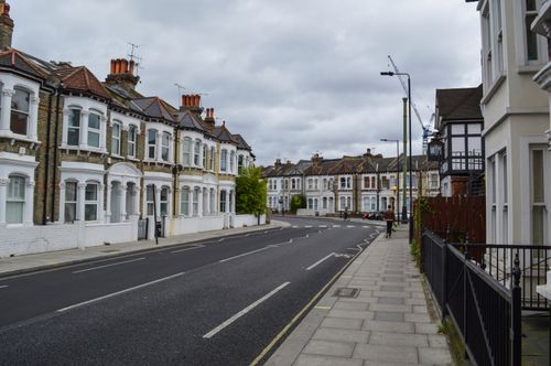 Free Exterior of contemporary solid houses and concrete road with pavement under cloudy nasty sky Stock Photo