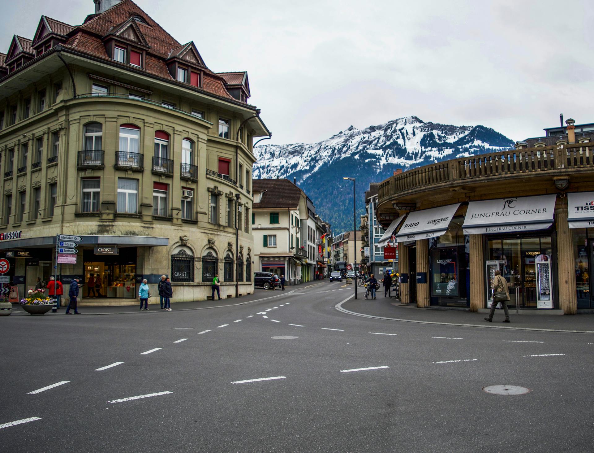 Picturesque street in Interlaken featuring traditional Swiss architecture and snowy mountain views.