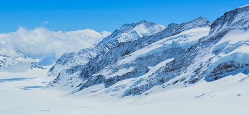 Free Scenery view of rough mounts with snow near clouds under bright sky in daylight Stock Photo