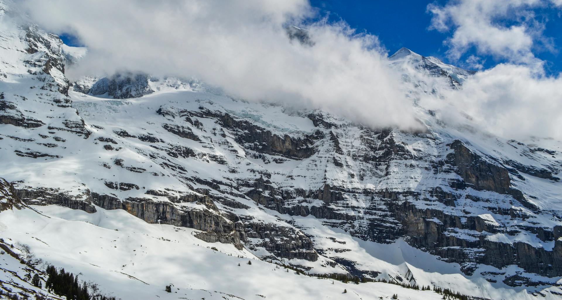 From below of rough ridge with snow under blue cloudy sky in wintertime in daylight