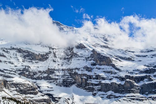 Free Rough snowy mount under sky in cold weather Stock Photo