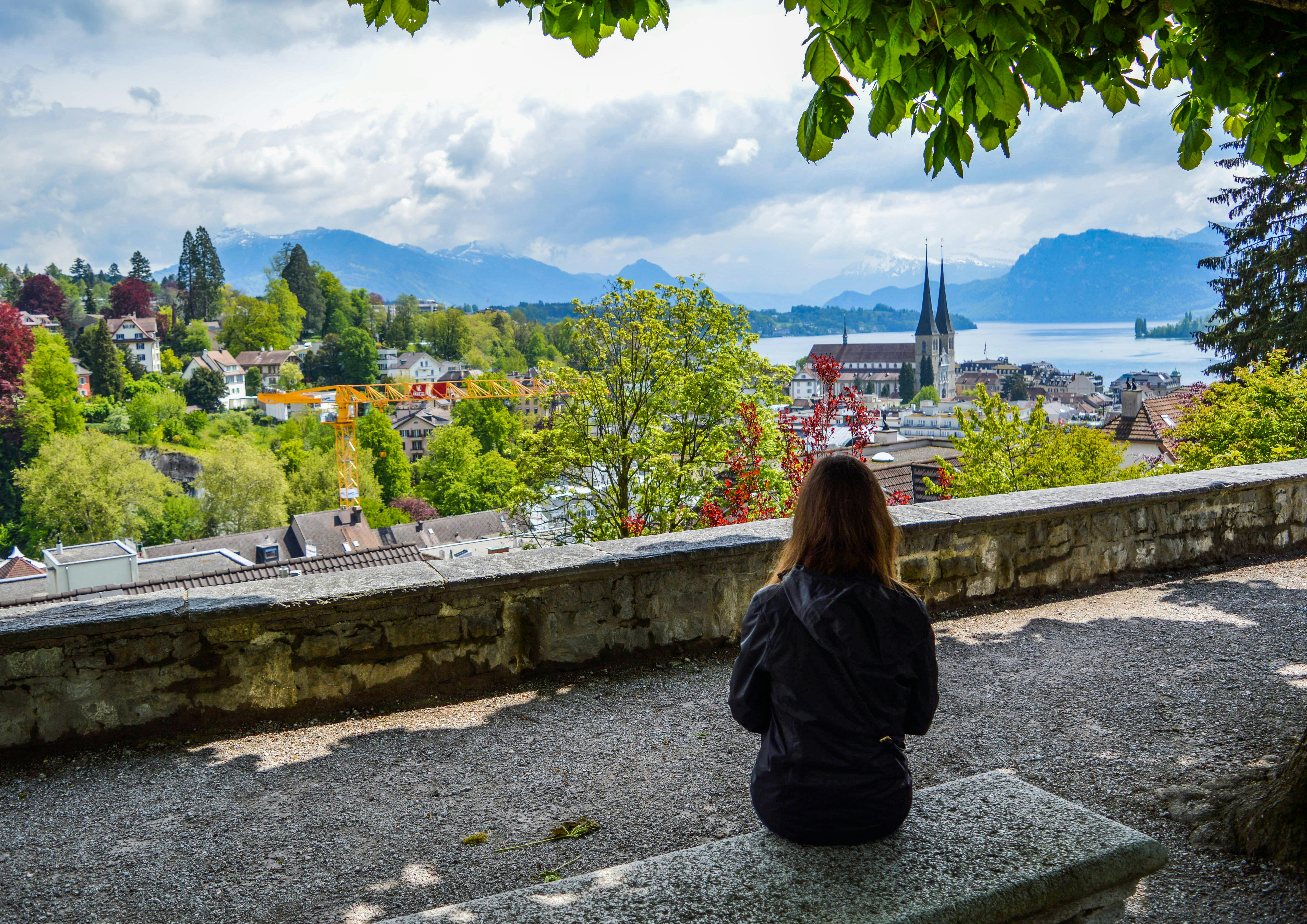Woman sitting on stone bench and looking at scenery