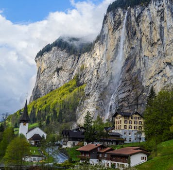 悬崖上坐落着一个风景如画的村庄，瀑布倾泻而下，构成了一幅宁静而雄伟的自然画卷