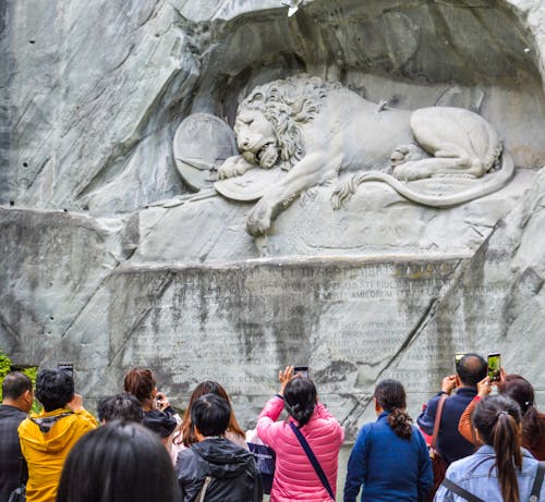 Free Tourists standing near Lion Monument in Switzerland Stock Photo