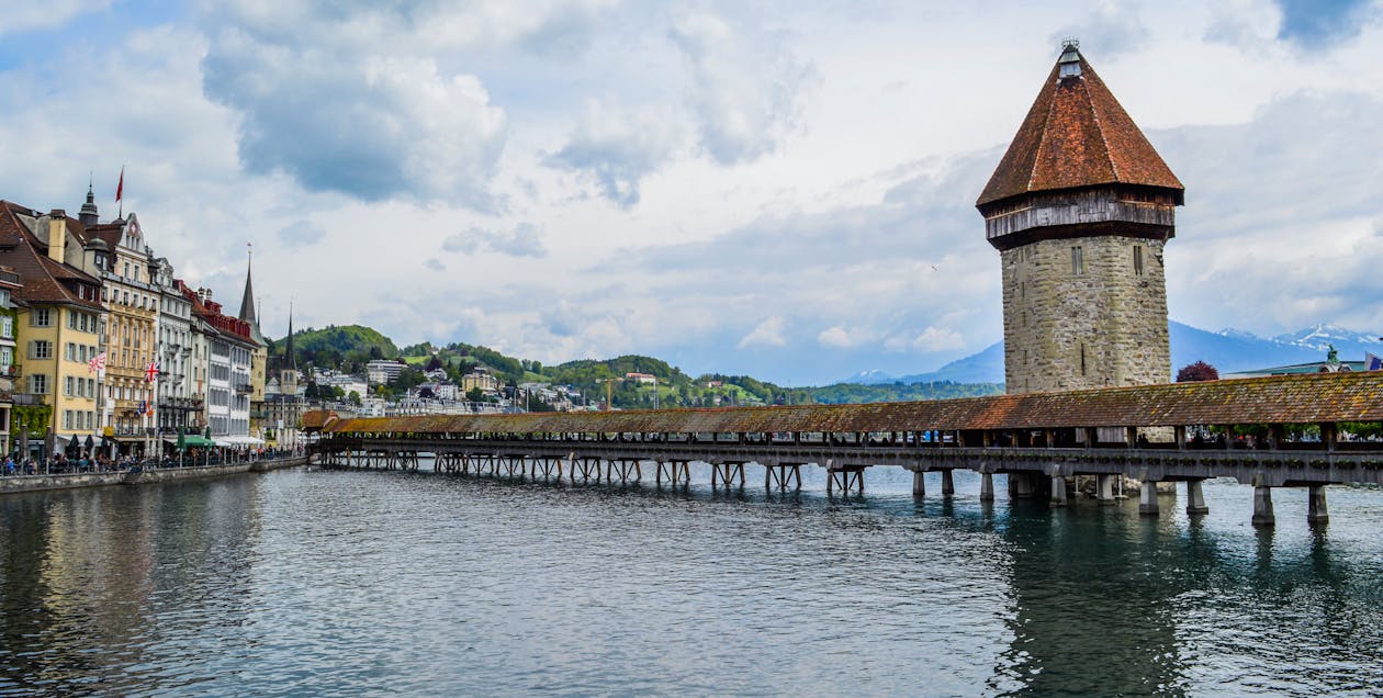 Free Exterior of medieval Chapel Bridge crossing rippling river in town of Lucerne in cloudy day Stock Photo