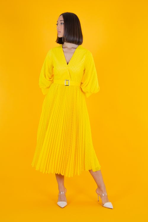 Free Stylish woman posing in a bright yellow dress against a matching background, exuding elegance. Stock Photo