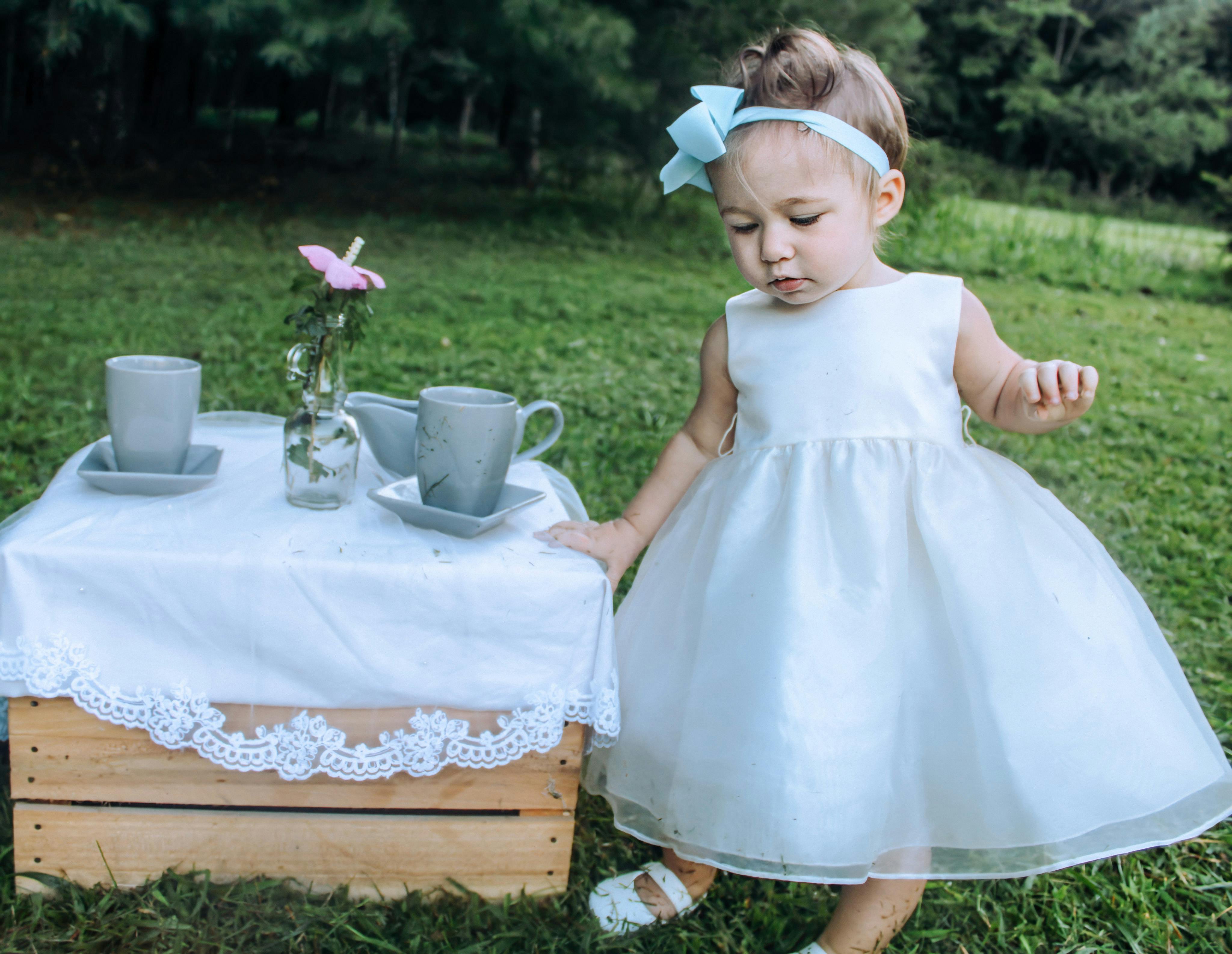 a little girl in a white gown