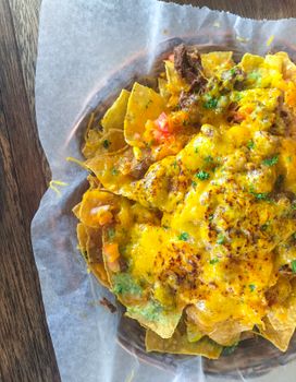 Mouthwatering nachos topped with cheese, beef, and fresh ingredients, perfect for a snack or Mexican cuisine lover.