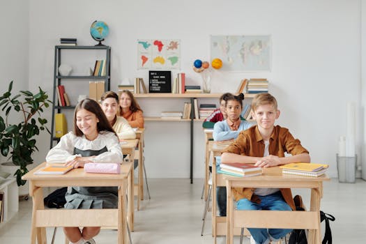 Photo by Max Fischer A group of happy students sitting at desks in a modern classroom environment.