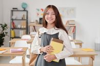 教室里，一个开朗的少女拿着笔记本，准备上学