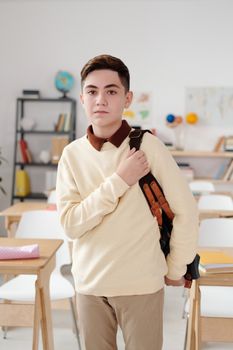 教室里，一个十几岁的男孩背着背包，若有所思