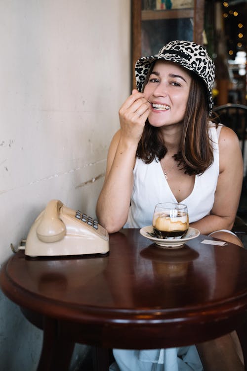 A Happy Woman Having Dessert beside a Rotary Phone