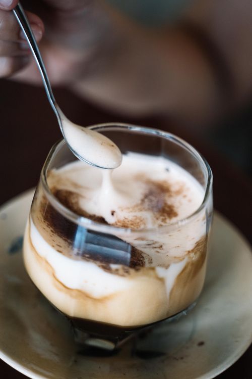 Free Close-up view of creamy cappuccino being stirred in a glass cup, creating artful swirls. Stock Photo