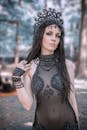 一位黑发优雅的角色扮演者，头戴复杂的哥特式头饰，正在户外摆姿势