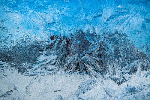 Free Close-up shot of delicate frost textures on a cold winter window, creating an abstract icy pattern. Stock Photo