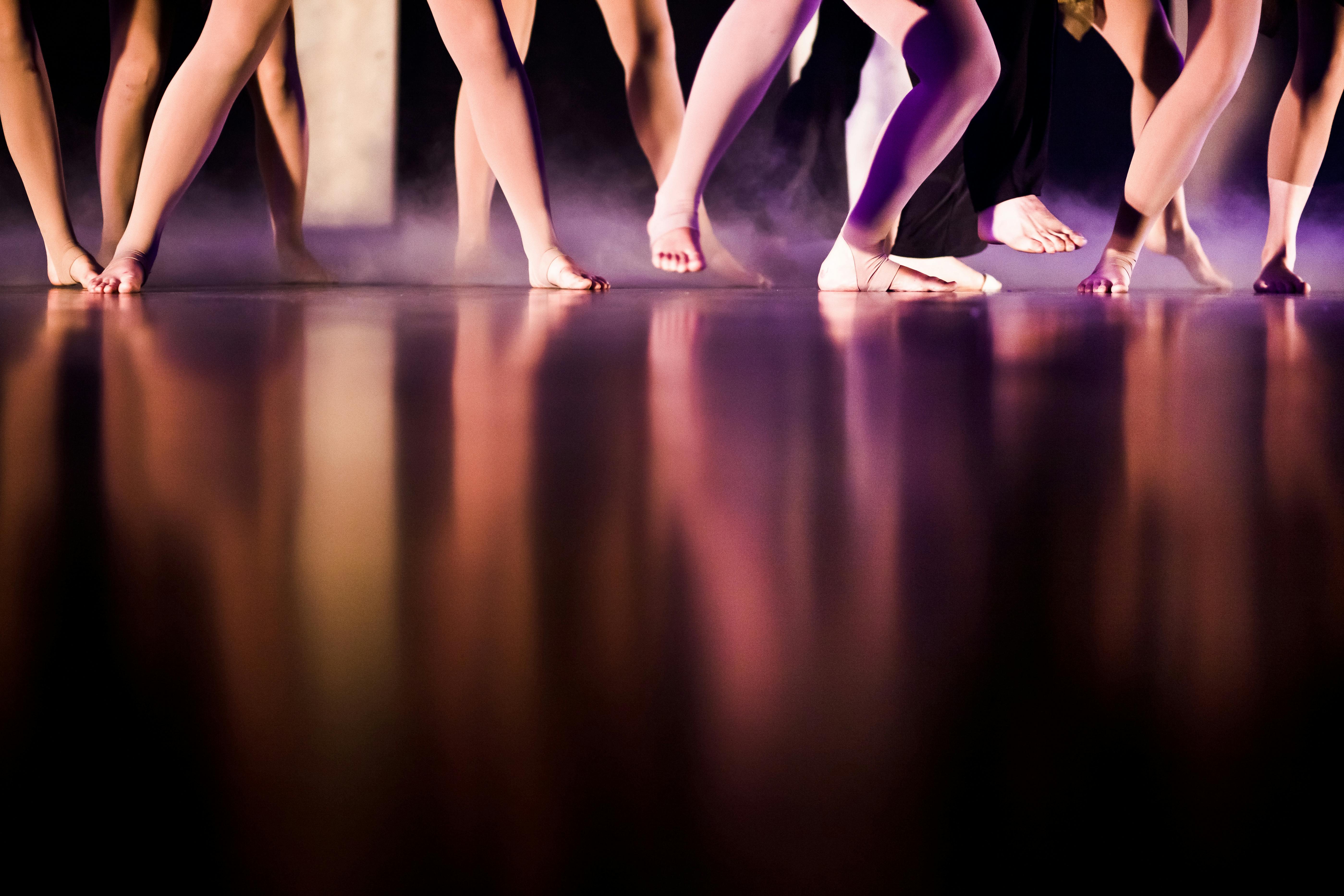 Free Artistic capture of dancers' feet reflecting on stage floor, creating a dramatic and elegant effect. Stock Photo
