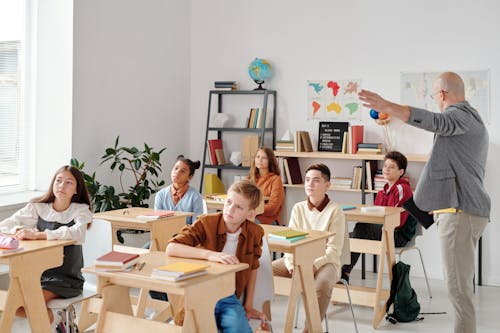 Free Children Sitting on Chair in Front of Table Stock Photo