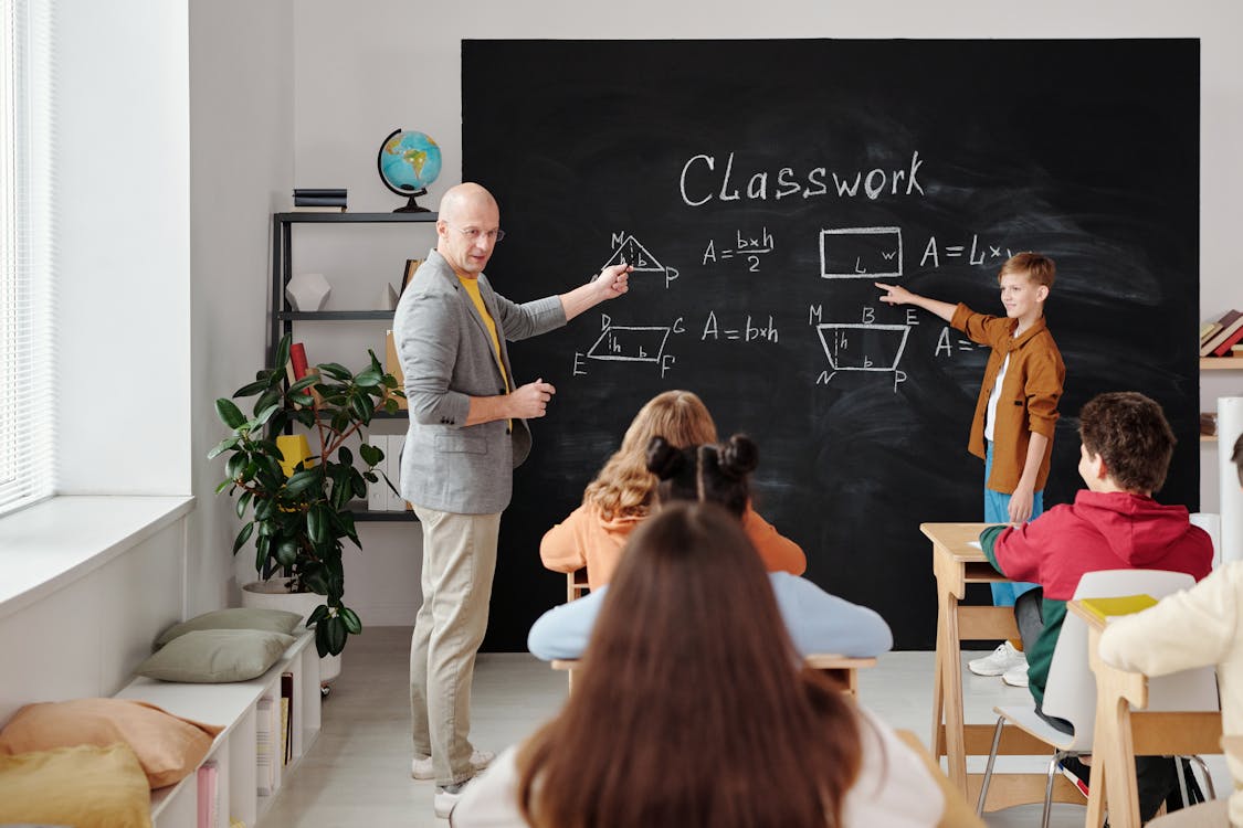 Insegnanti parlano a degli alunni in classe