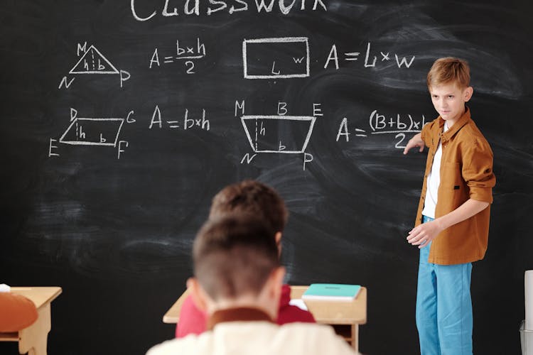 A Student Discussing In Front Of The Blackboard