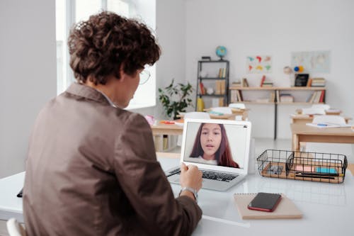 使用macbook Pro的灰色衬衫的男人