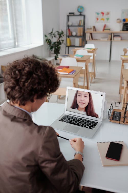 A Teacher Talking to her Student using a Laptop