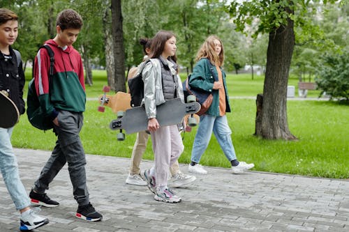 Uomo In Pantaloni Grigi Che Tiene Zaino Nero E Grigio Che Cammina Sul Percorso Di Cemento Grigio