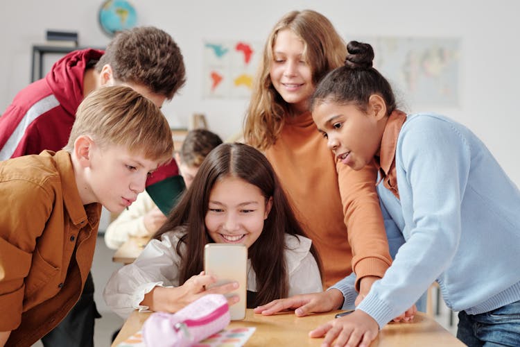 A Boys And Girls Watching On The Smartphone Together