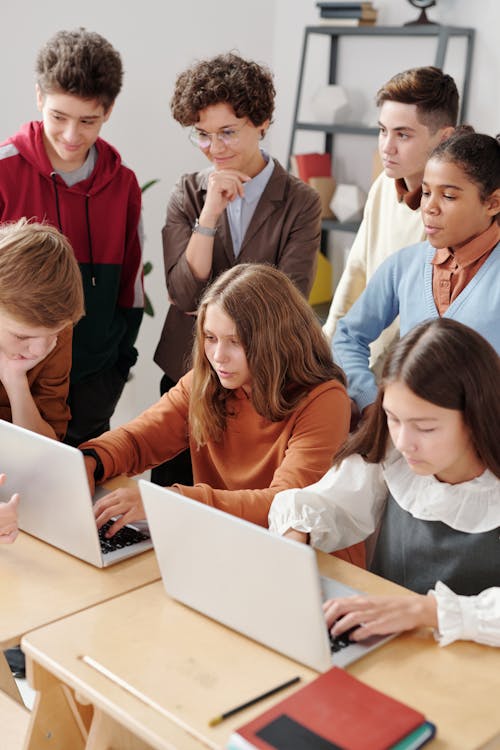 Free A Two Girls Using Laptop with Classmates Stock Photo