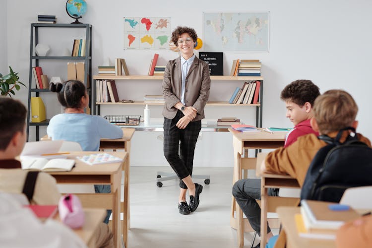 A Teacher Standing In The Classroom