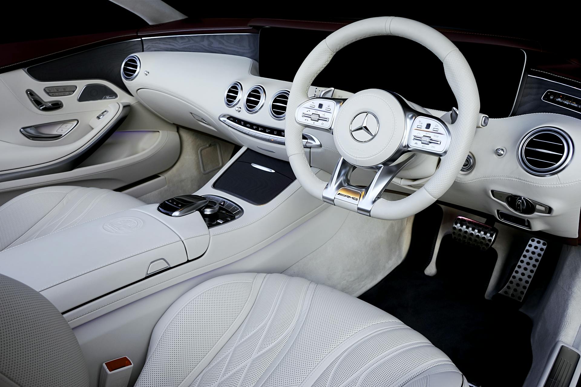 Explore the sleek, luxurious white leather interior of a high-end automobile with advanced features.