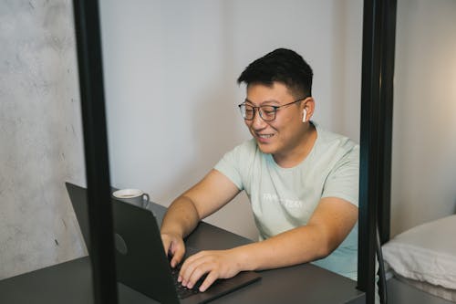 Man in Crew Neck T-shirt Using Black Laptop Computer