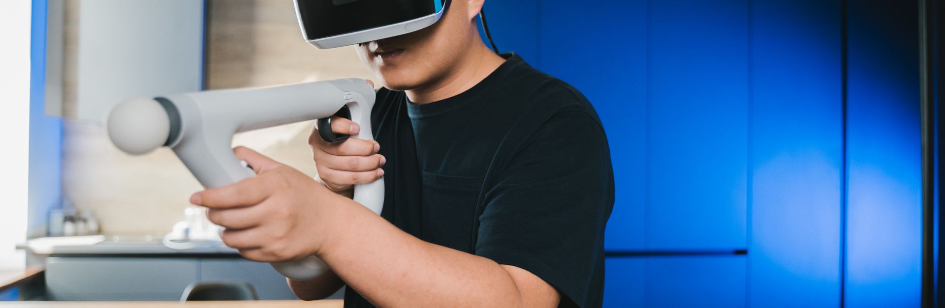 A man using a virtual reality headset and controller for an immersive gaming experience at home.