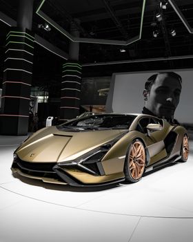 Stunning gold Lamborghini sports car displayed in Frankfurt's auto exhibition hall.