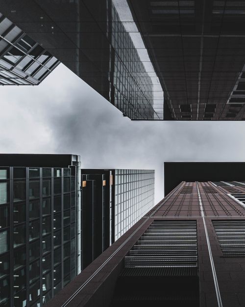 Free Low-angle view of modern skyscrapers in Frankfurt, highlighting architectural lines against a cloudy sky. Stock Photo