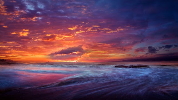 Stunning ocean sunset with vibrant clouds and waves, perfect for nature enthusiasts.