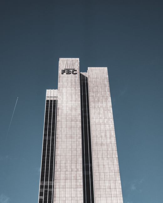 High-rise FBC building tower against a clear blue sky in Frankfurt, Germany.