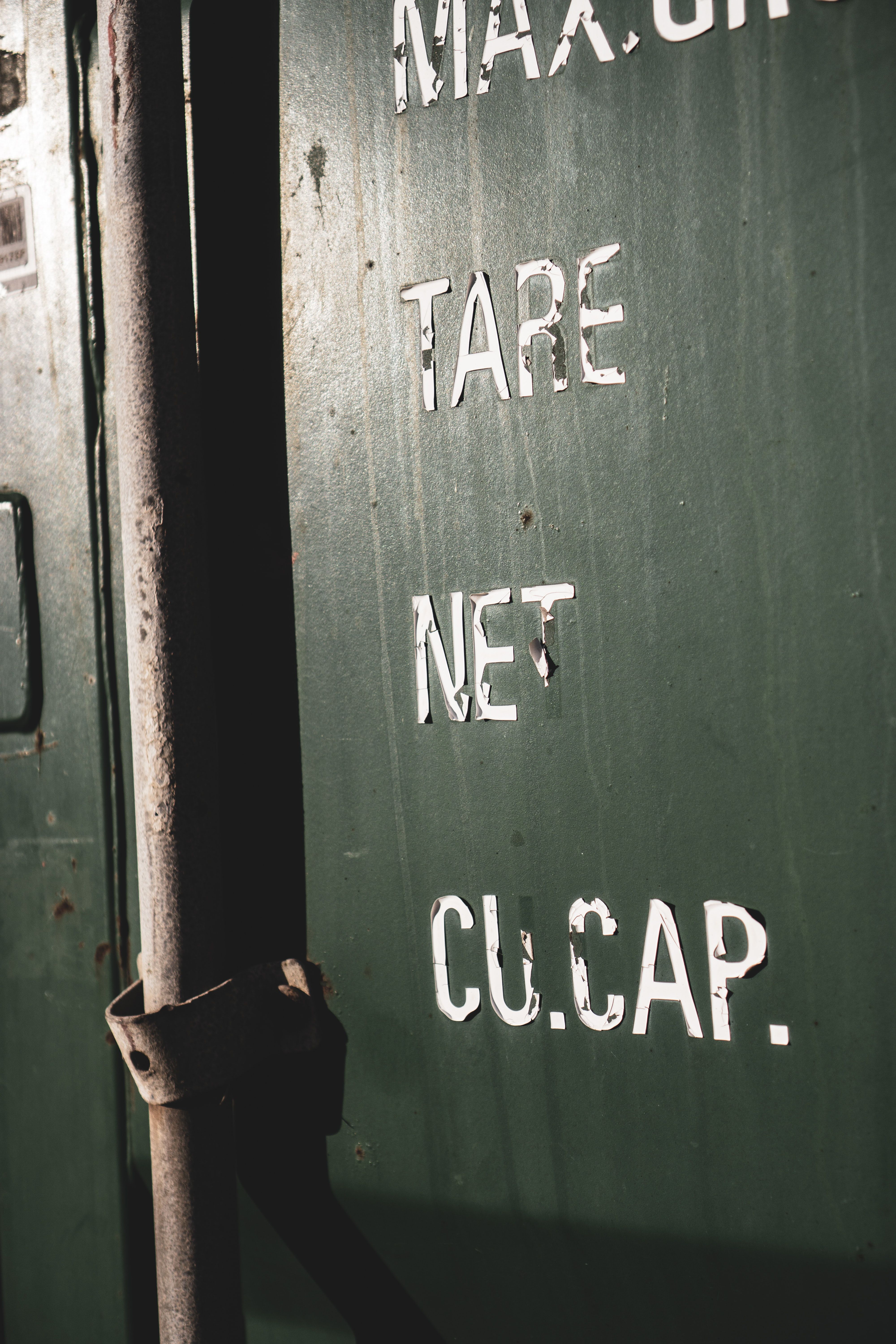 Detailed view of rusty industrial metal container with text visible.