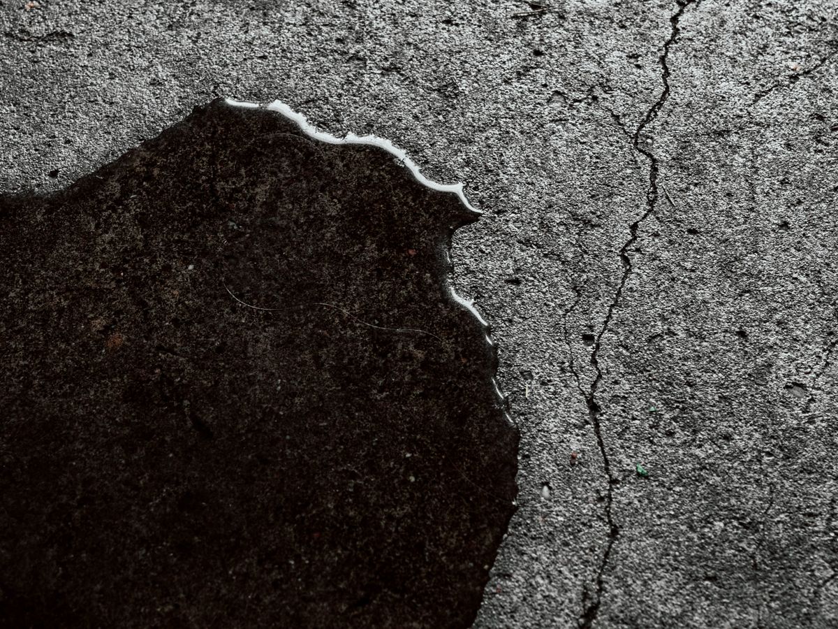 Detailed image of a wet cracked concrete surface with standing water