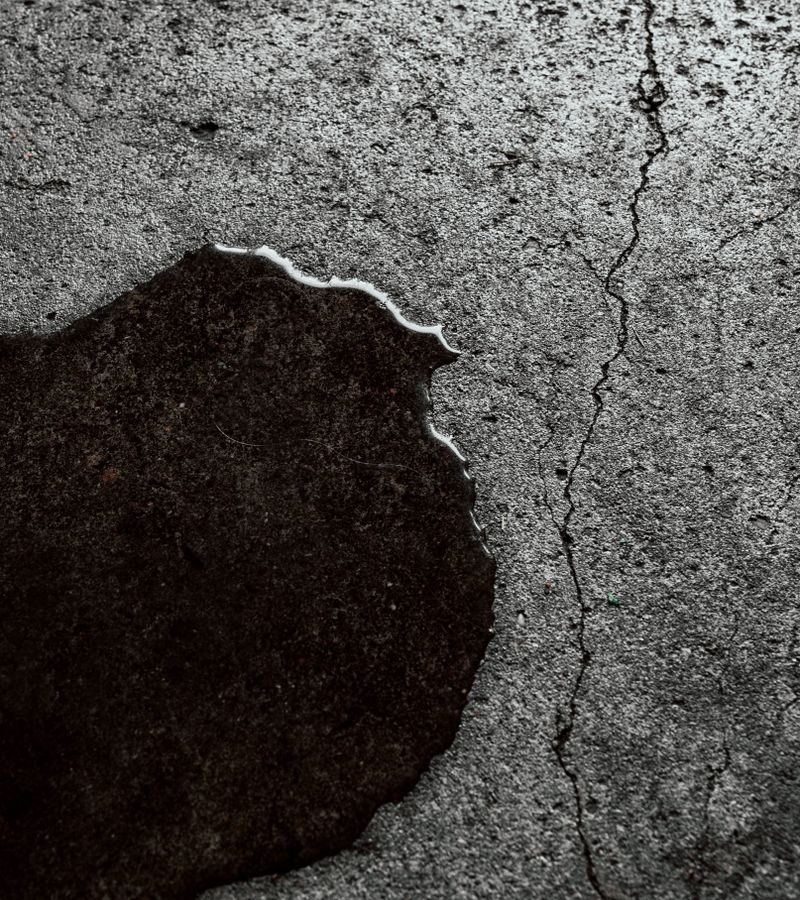 Wet cracked concrete floor with standing water after a storm