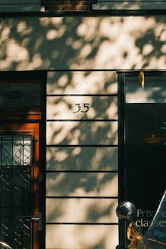 Sunlit urban doorway with shadows and architectural details in a residential area.