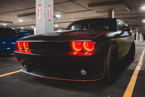 Free Luxury muscle  car with chrome body and bright red headlights on asphalt parking lot Stock Photo