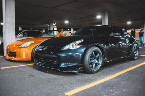 Free Contemporary shiny prestigious cars of black and dark yellow colors parked on asphalt ground in indoors parking Stock Photo