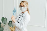 医护人员穿着白外套、戴着口罩和手套，手持听诊器