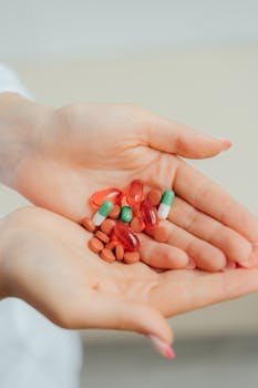 Close-up shot of hands holding assorted pills and capsules, emphasizing health and medication.