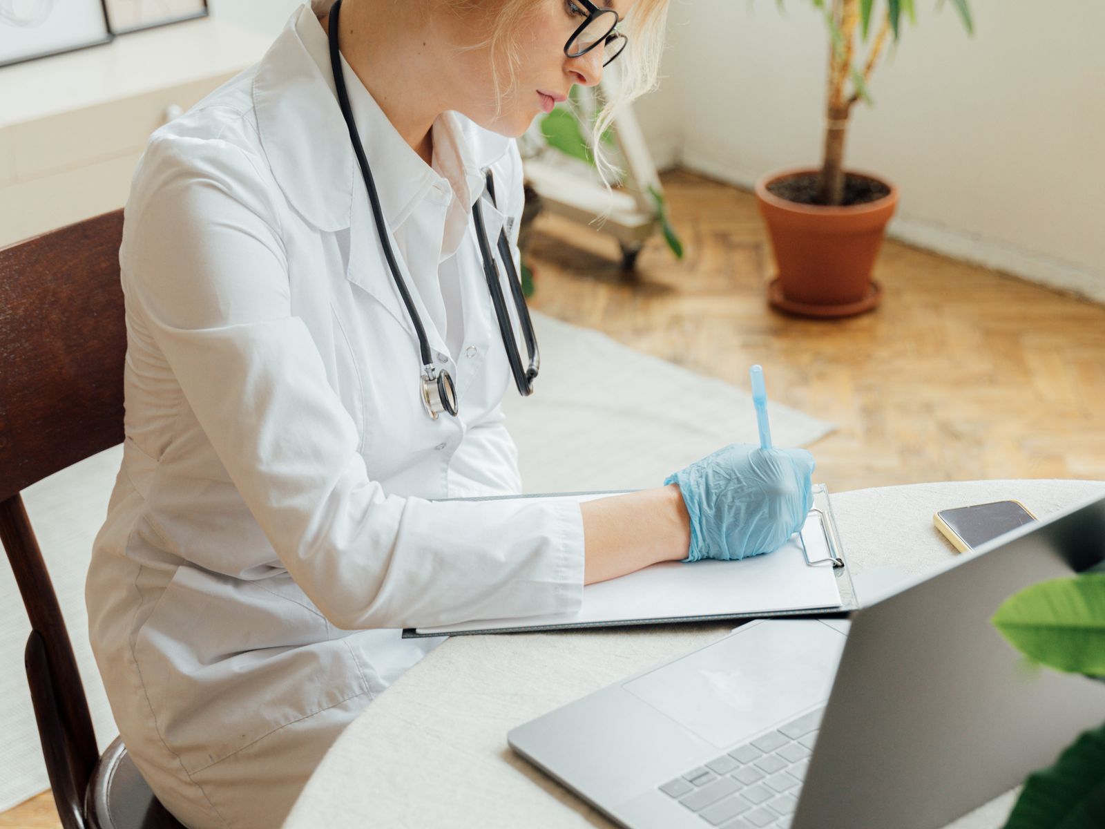 Healthcare professional using a laptop or tablet in a modern practice office