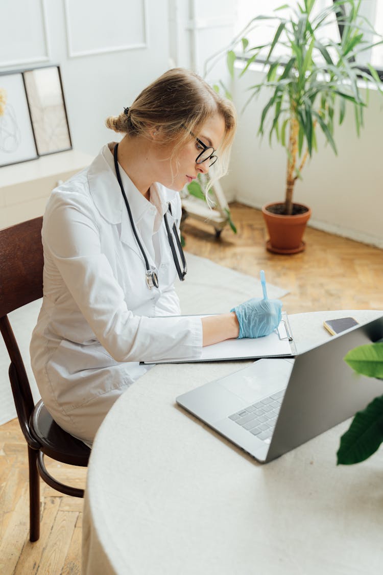 A Doctor Writing On A Clipboard