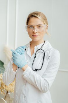 一位女医生戴着手套和护目镜，准备在医疗保健环境中执勤